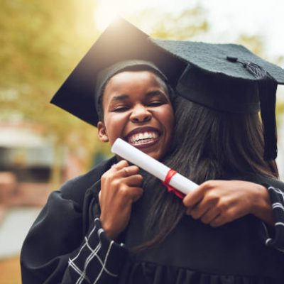 Shot of two graduates embracing each other on graduation day
